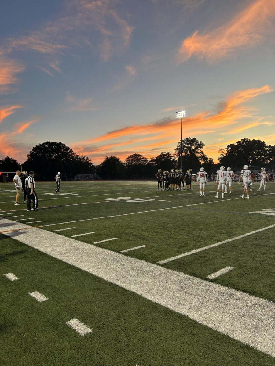 A picture of a beautiful night sky gets photobombed by a Friday night football game.