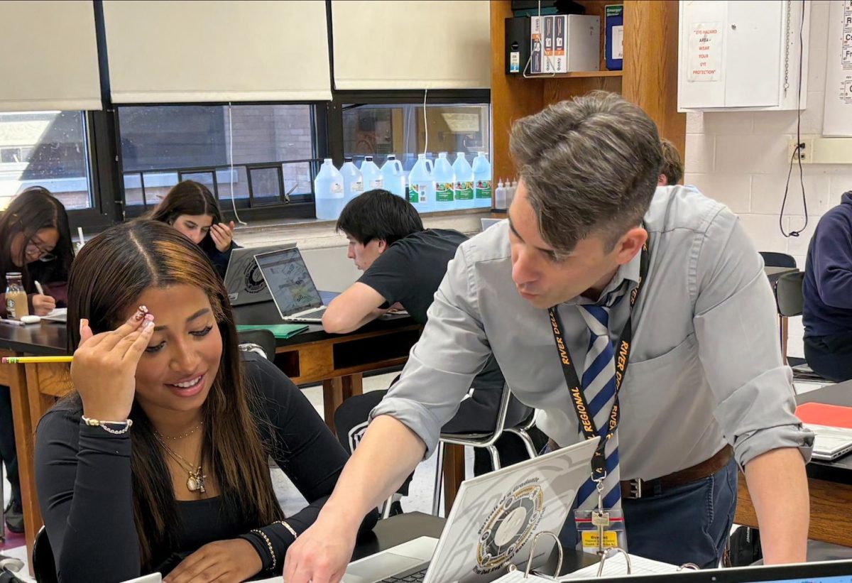 Mr. Valentino assists 11th grader Mia Dume Geronimo.
