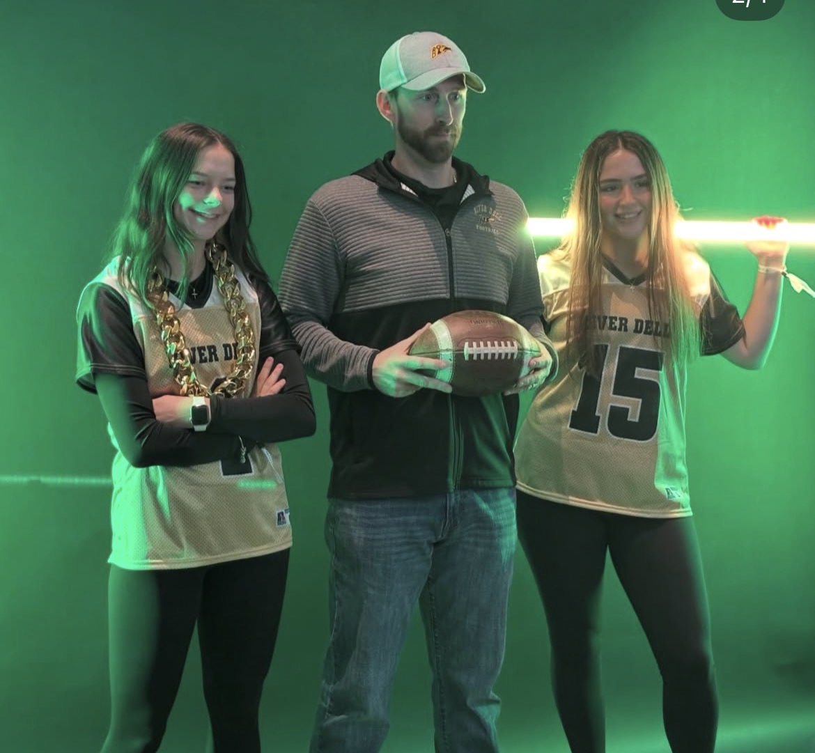 Emma Yeandle, Kai Grebla, and Coach Aliano pose in front of what could only be described as what 1998 said 2026 would look like.